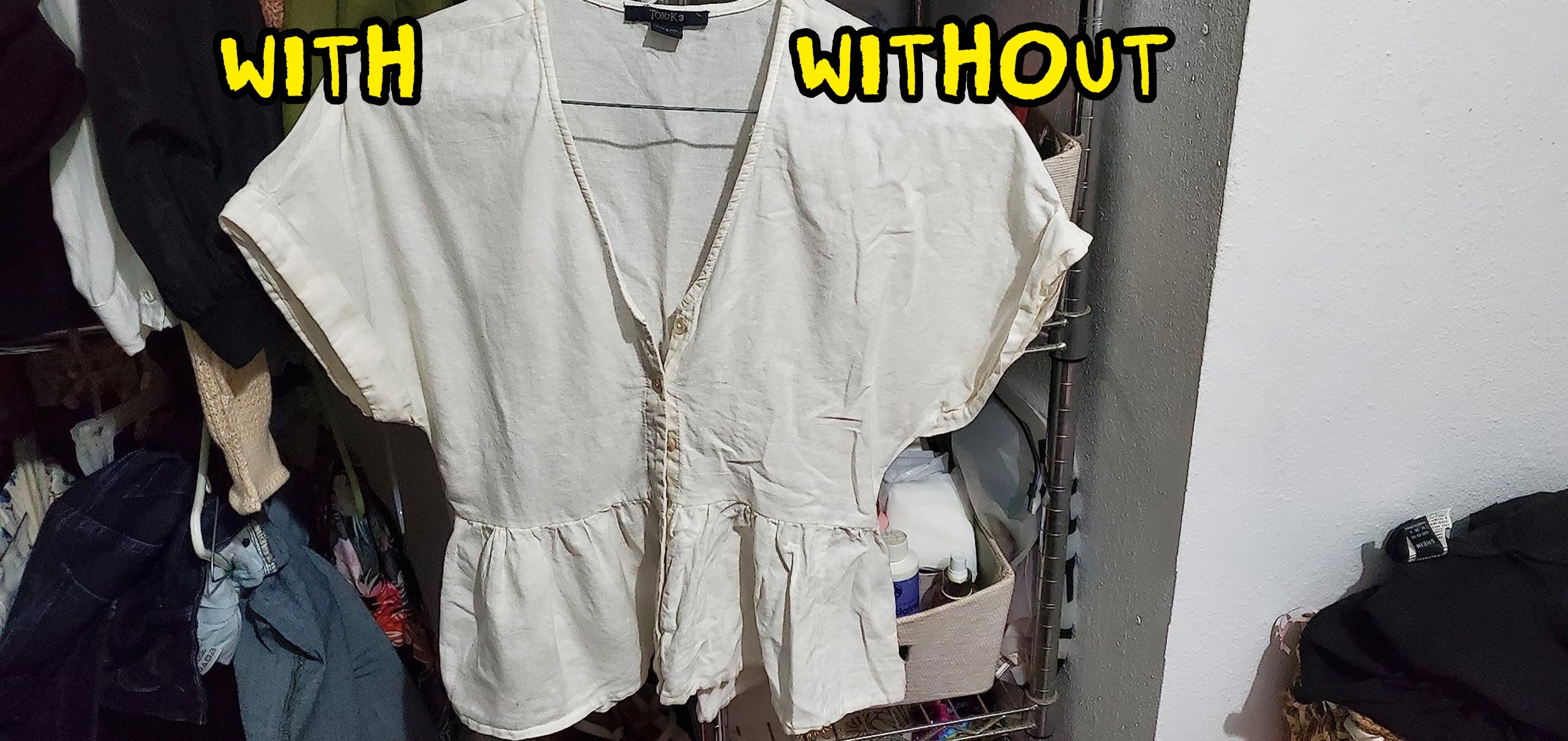 A beige short-sleeve blouse with a ruffled waist hangs in a closet, surrounded by various clothes and items