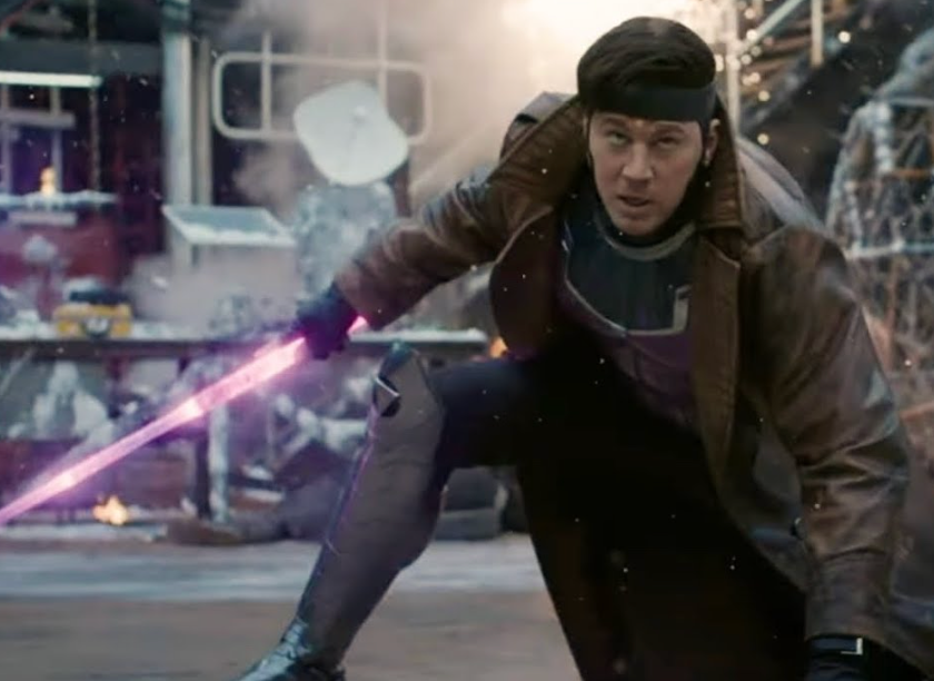 A person in a futuristic outfit kneels, wielding a glowing, sword-like weapon in an action-packed scene