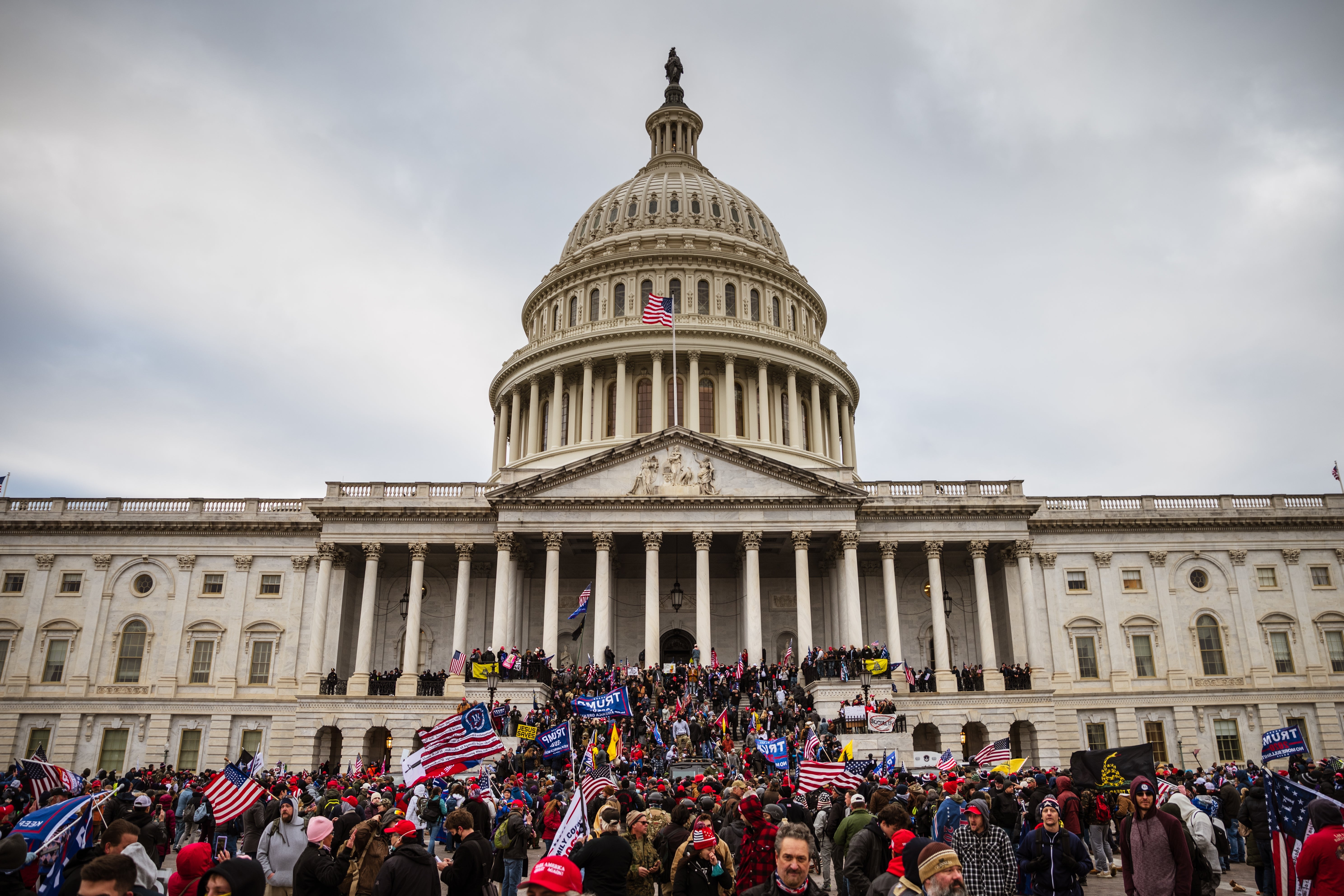 Folkemengder samlet seg utenfor US Capitol-bygningen med mange som holdt flagg, og skapte en travel scene på trappene og plenen foran den ikoniske strukturen