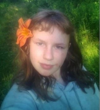 Damron poserte for en selfie utendørs med en blomst i håret