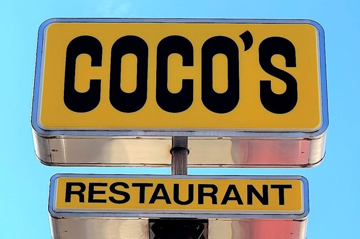 「COCO'S RESTAURANT」の看板が青空の背景に掲げられている。