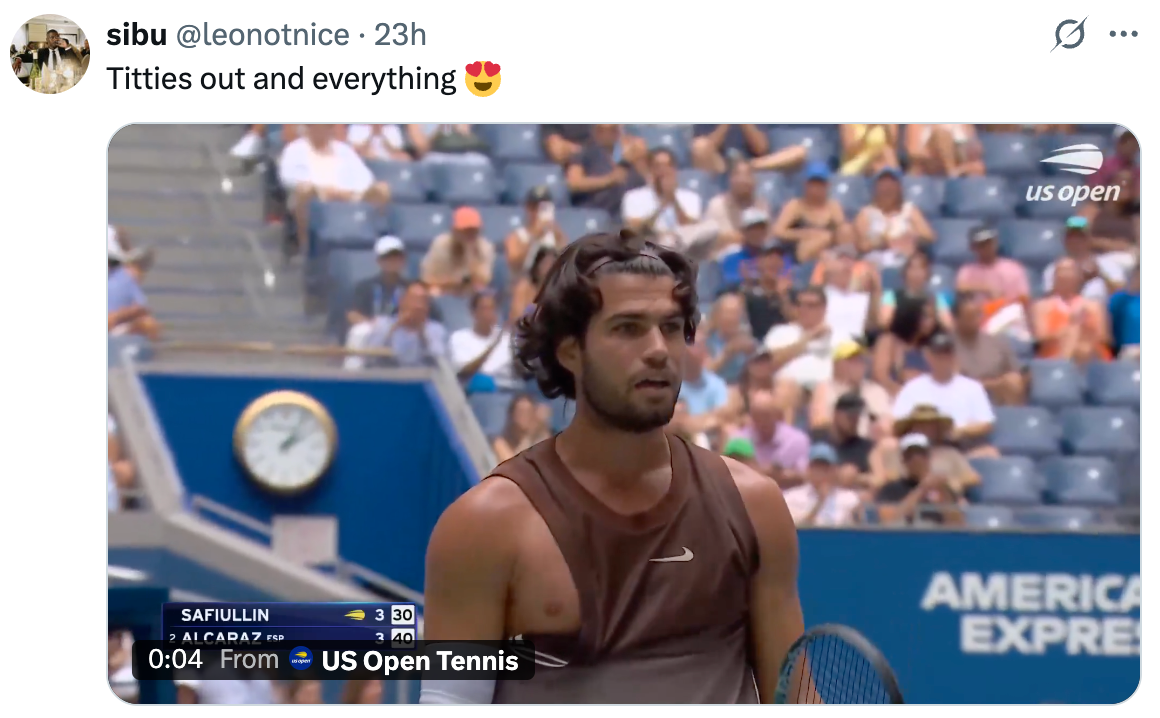 Tennisspiller på banen ved US Open med en folkemengde i bakgrunnen, iført en ermeløs skjorte