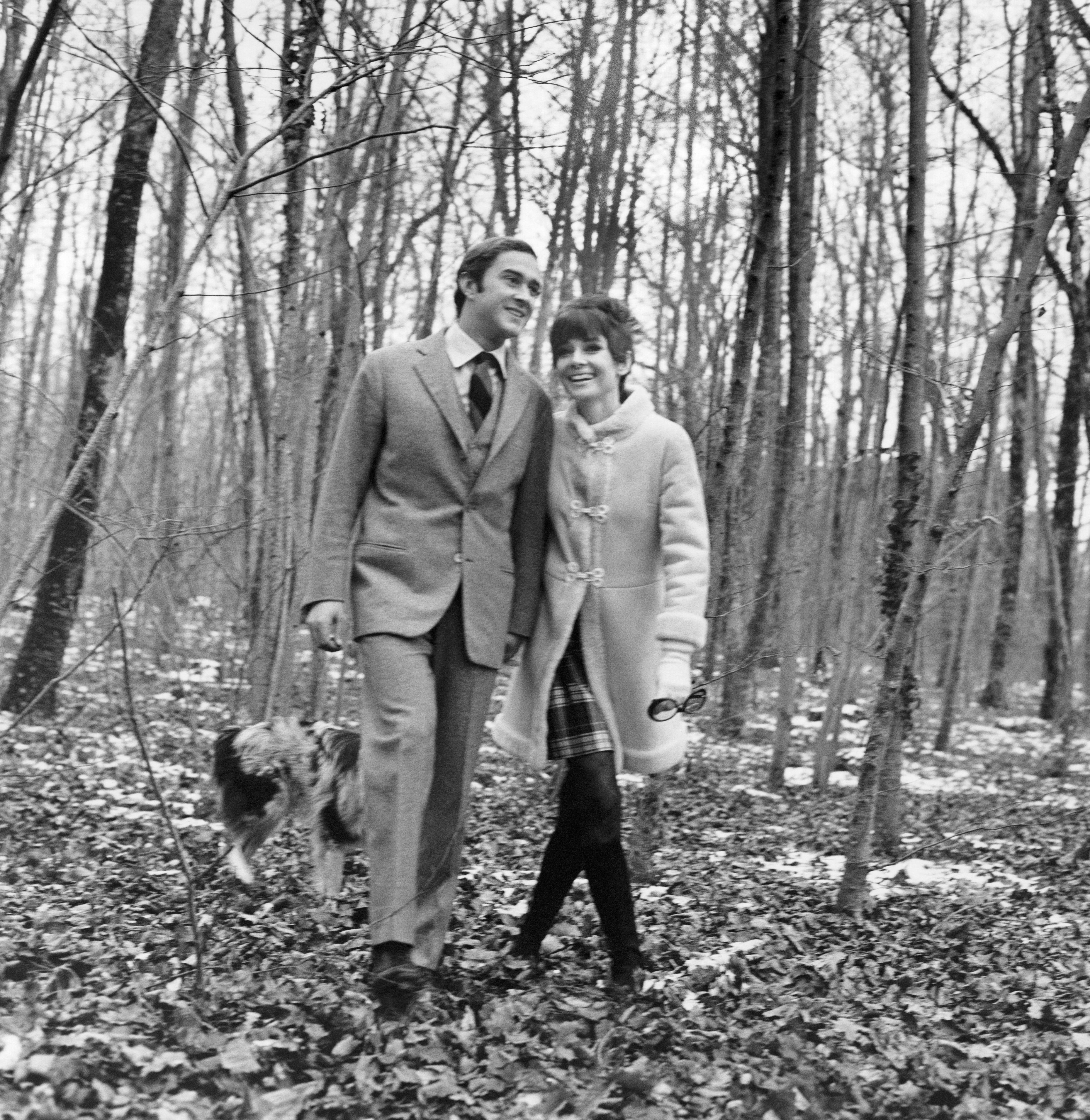 Audrey and Andrea and a dog walk through a wooded area.