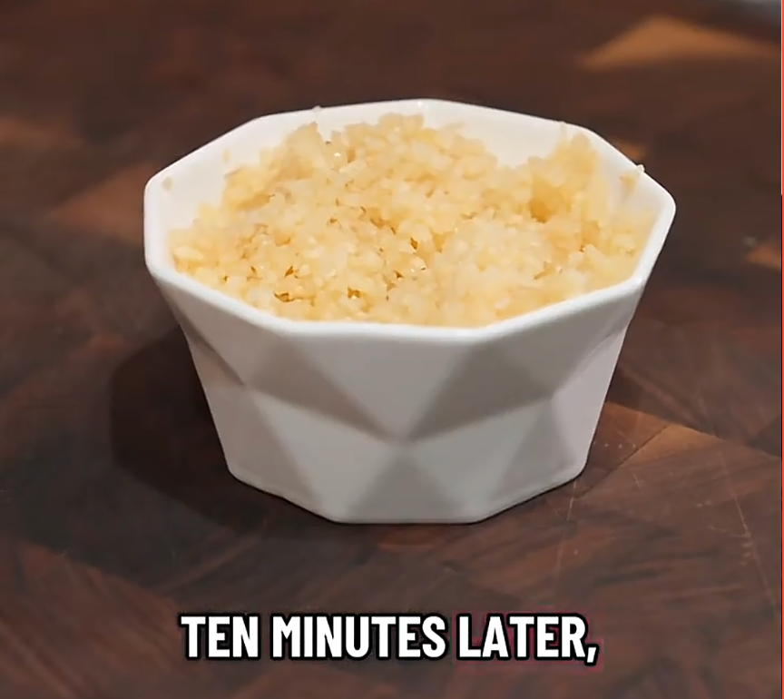 Bowl of fluffy, cooked rice on a wooden surface with text "TEN MINUTES LATER" below