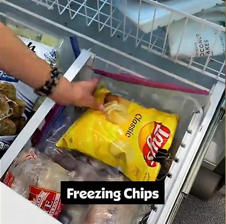 A hand places a bag of Lay's Classic chips in a freezer drawer containing other frozen items. Text on image says "Freezing Chips."
