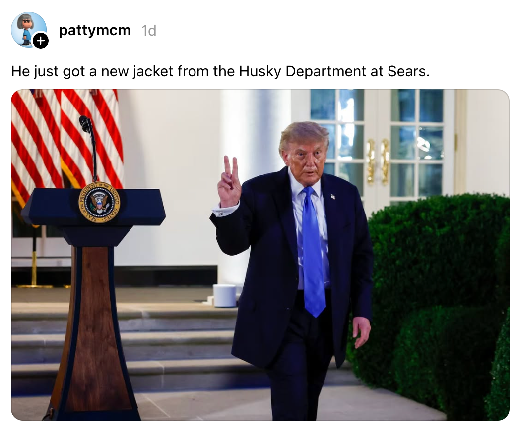 Person i dress som lager et fredstegn, går nær et podium med en presidentsegl, ved siden av flagg