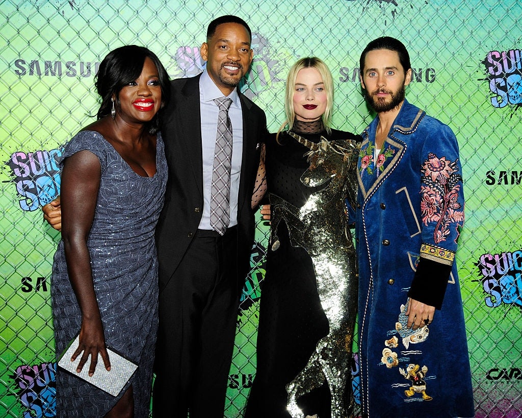 Four actors pose together at an event, featuring elegant and ornate outfits