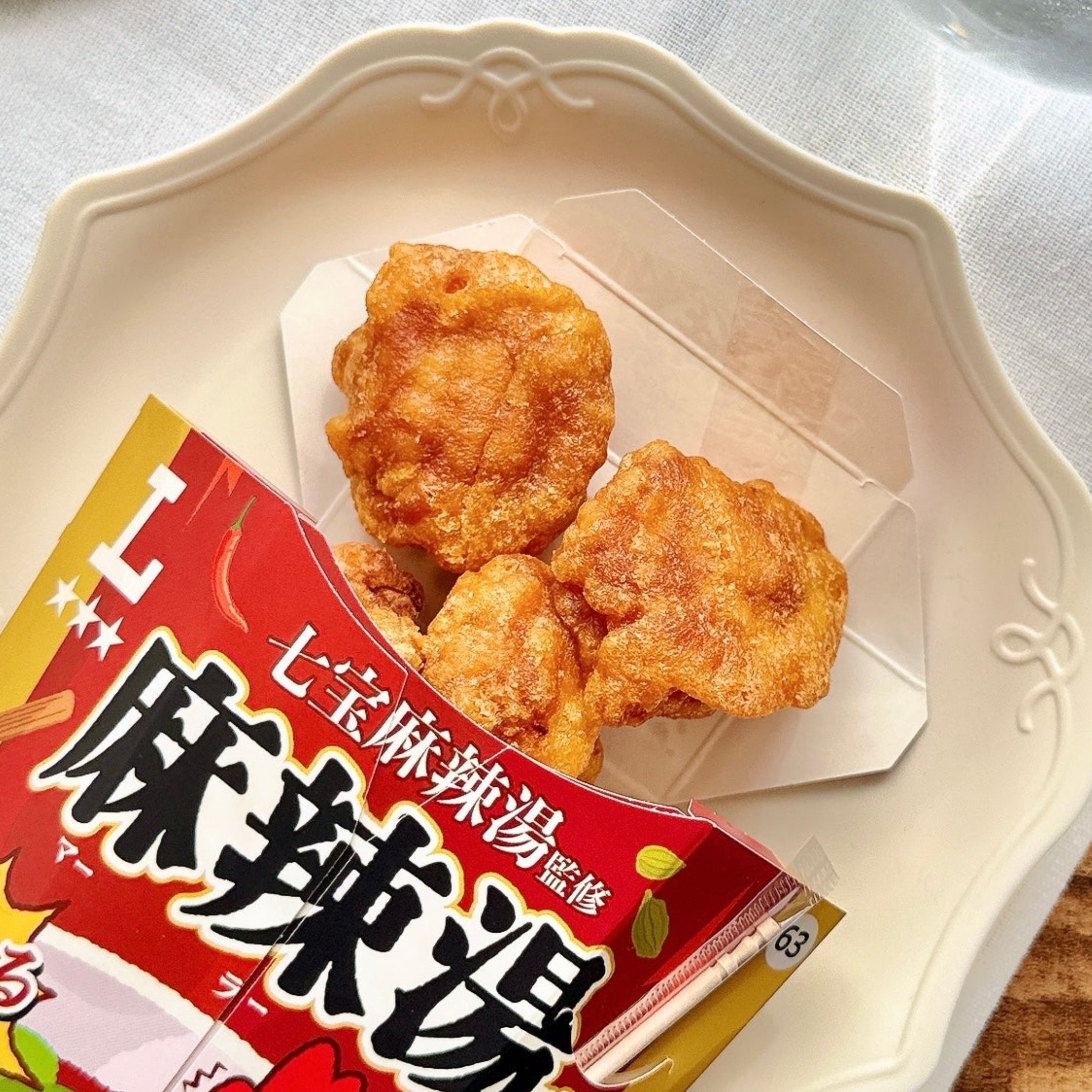 カップに入ったローソン 「からあげクン 七宝麻辣湯監修 麻辣湯味」がテーブルに置かれている。