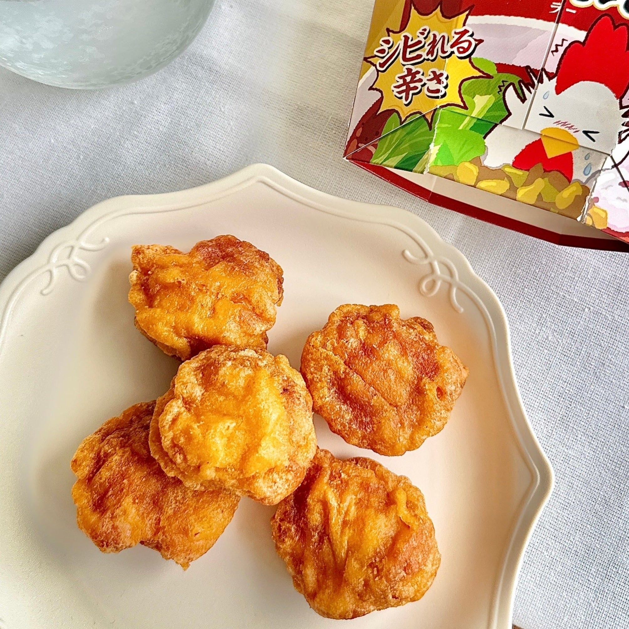 皿にのったローソン 「からあげクン 七宝麻辣湯監修 麻辣湯味」とパッケージがテーブルに置かれている。