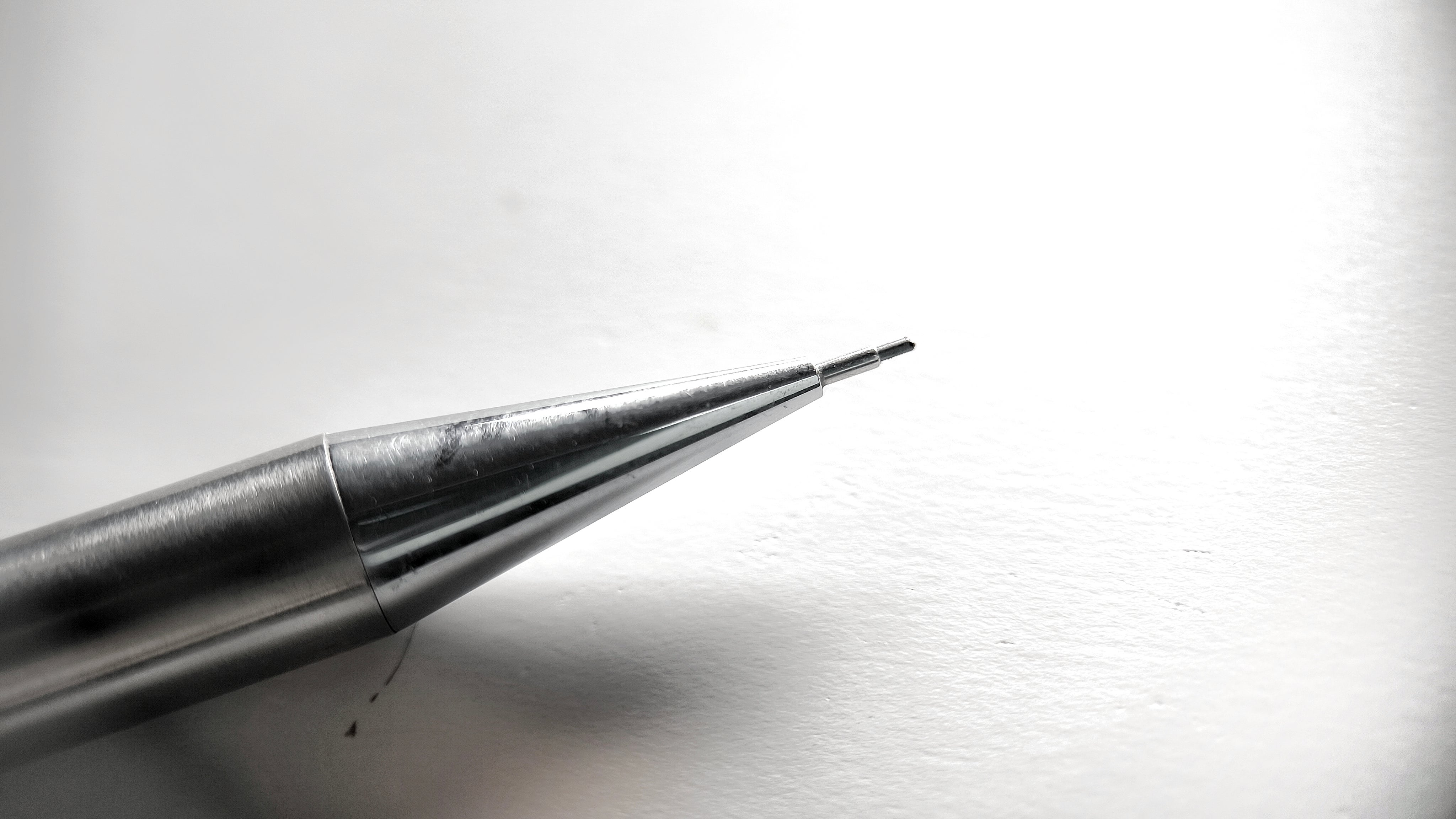 Close-up of a mechanical pencil tip on a white surface