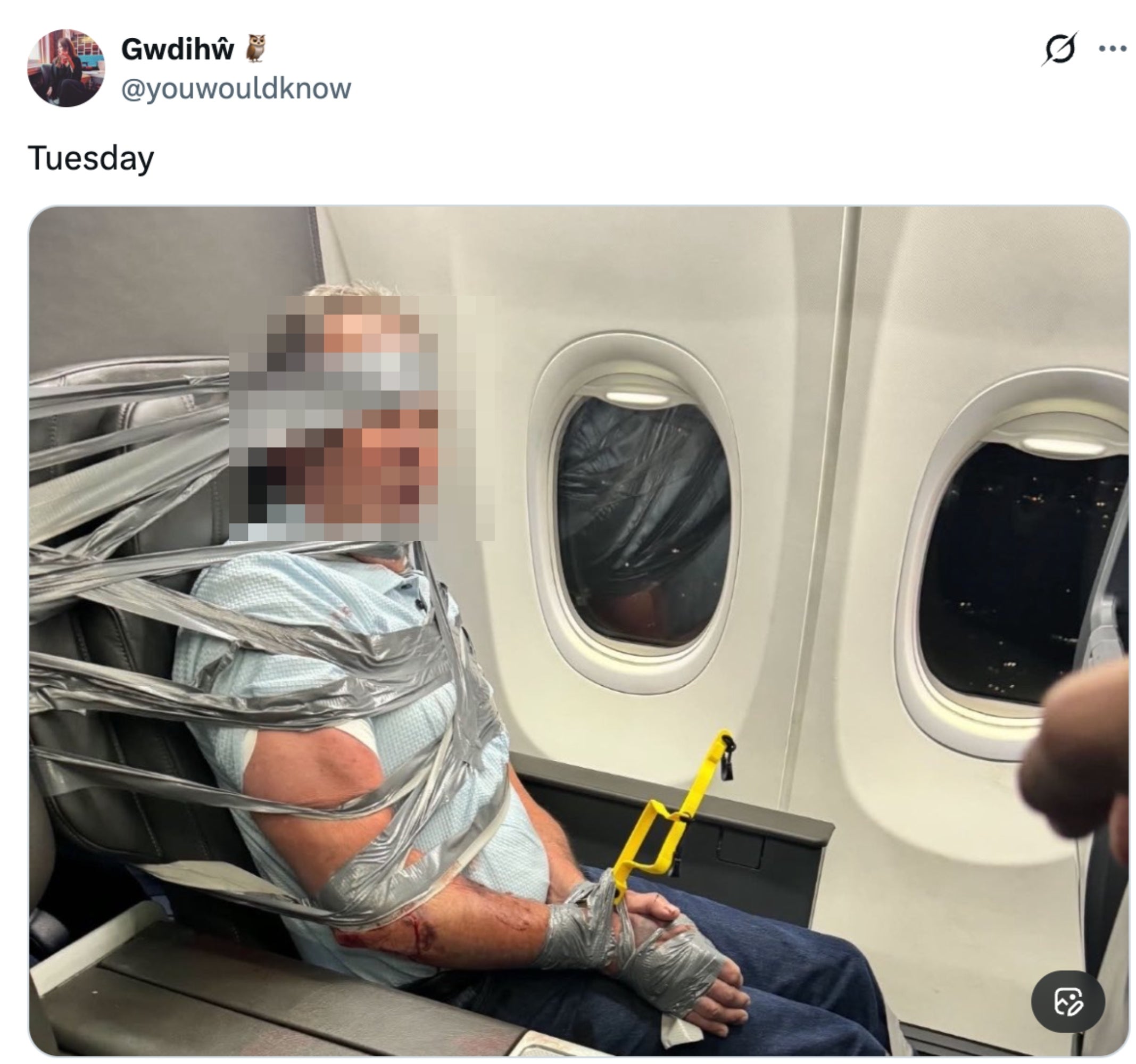 En person teipet til et flysete med gaffatape, og så lett fortvilet ut