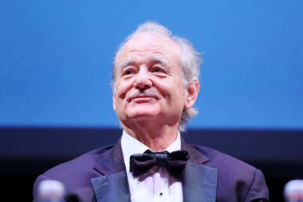 A person in a tuxedo with a bow tie at a formal event. They appear to be looking up with a neutral expression
