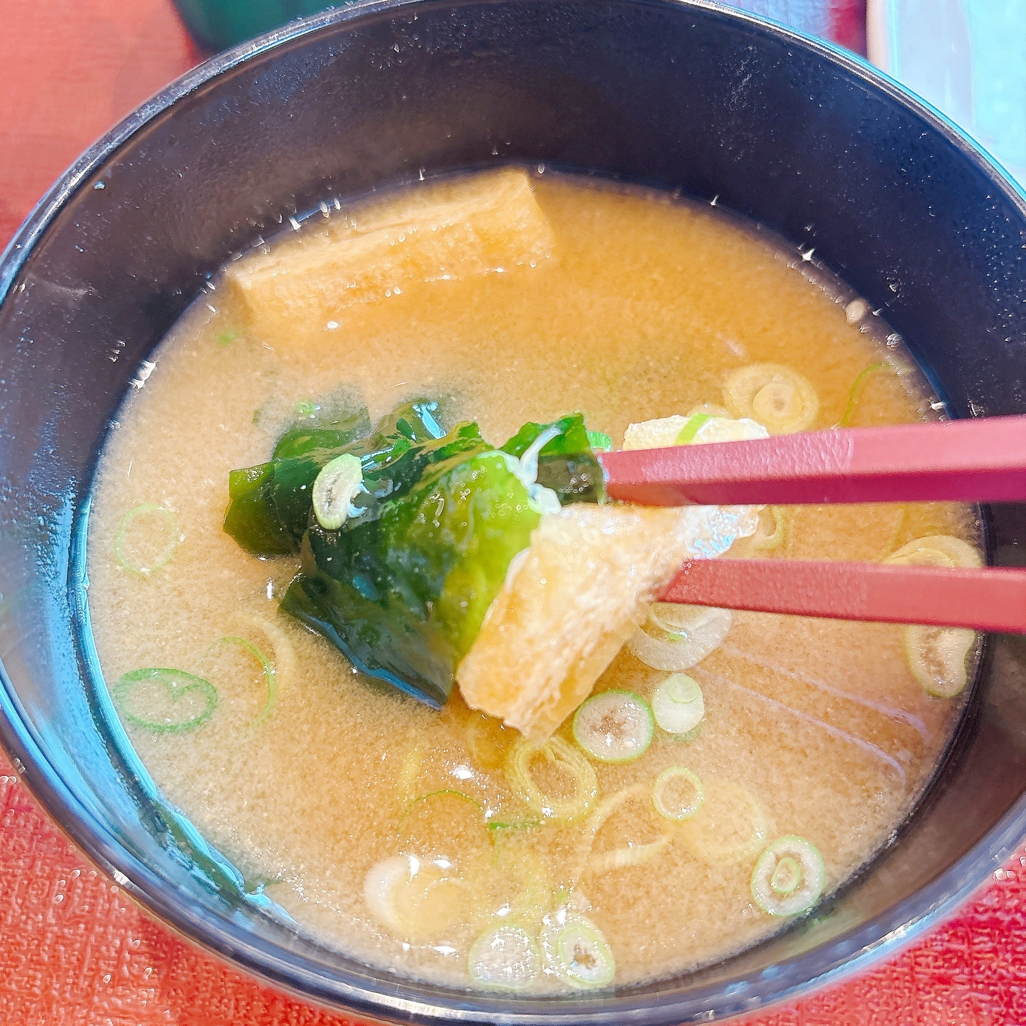 なか卯の「まぜのっけごはん朝食」味噌汁の具材を箸で持ち上げている様子。