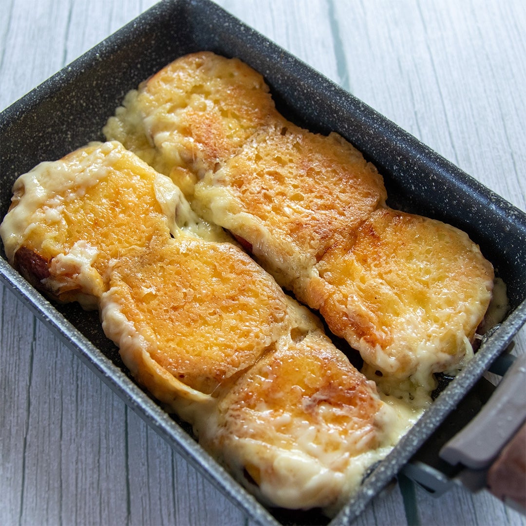 卵焼き器の中で焼かれているチーズとさつまいもの料理。