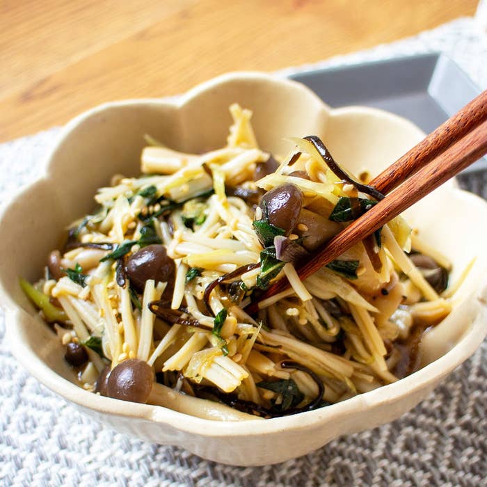 きのこと野菜が盛られた皿。箸で一部が持ち上げられている。