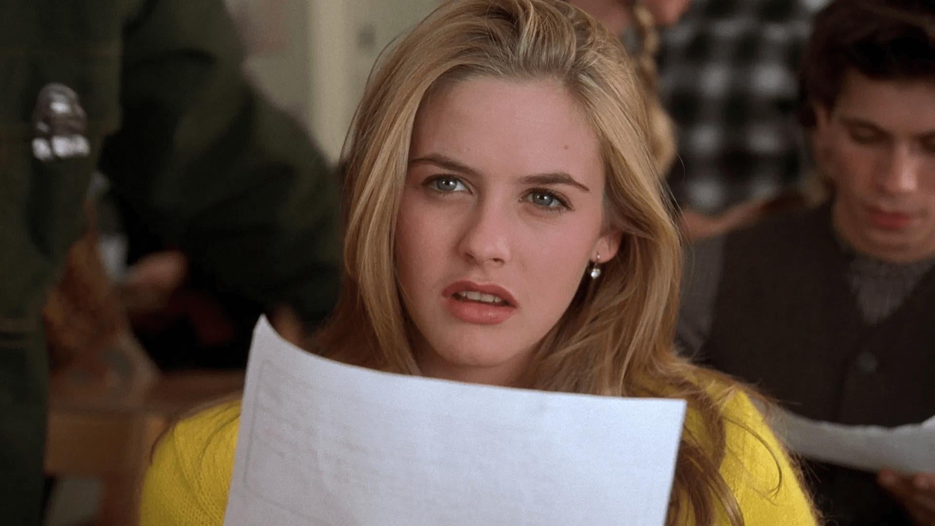 Person holding a paper, looking perplexed, in a classroom setting