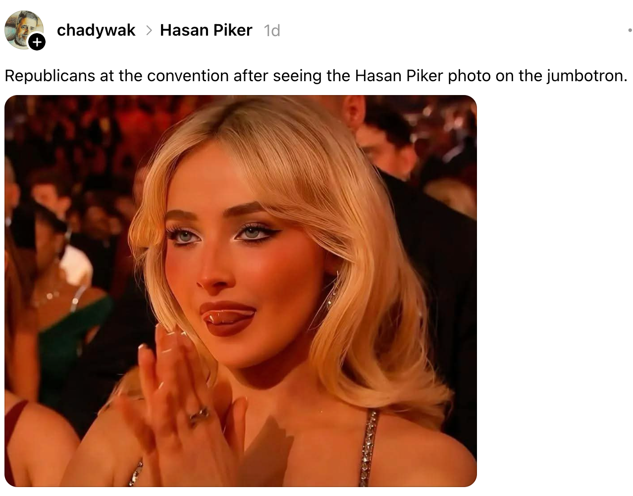 Person på scenen som klapper med et underholdt uttrykk på et stevne, referert til i en bildetekst som reagerer på et bilde av Hasan Piker