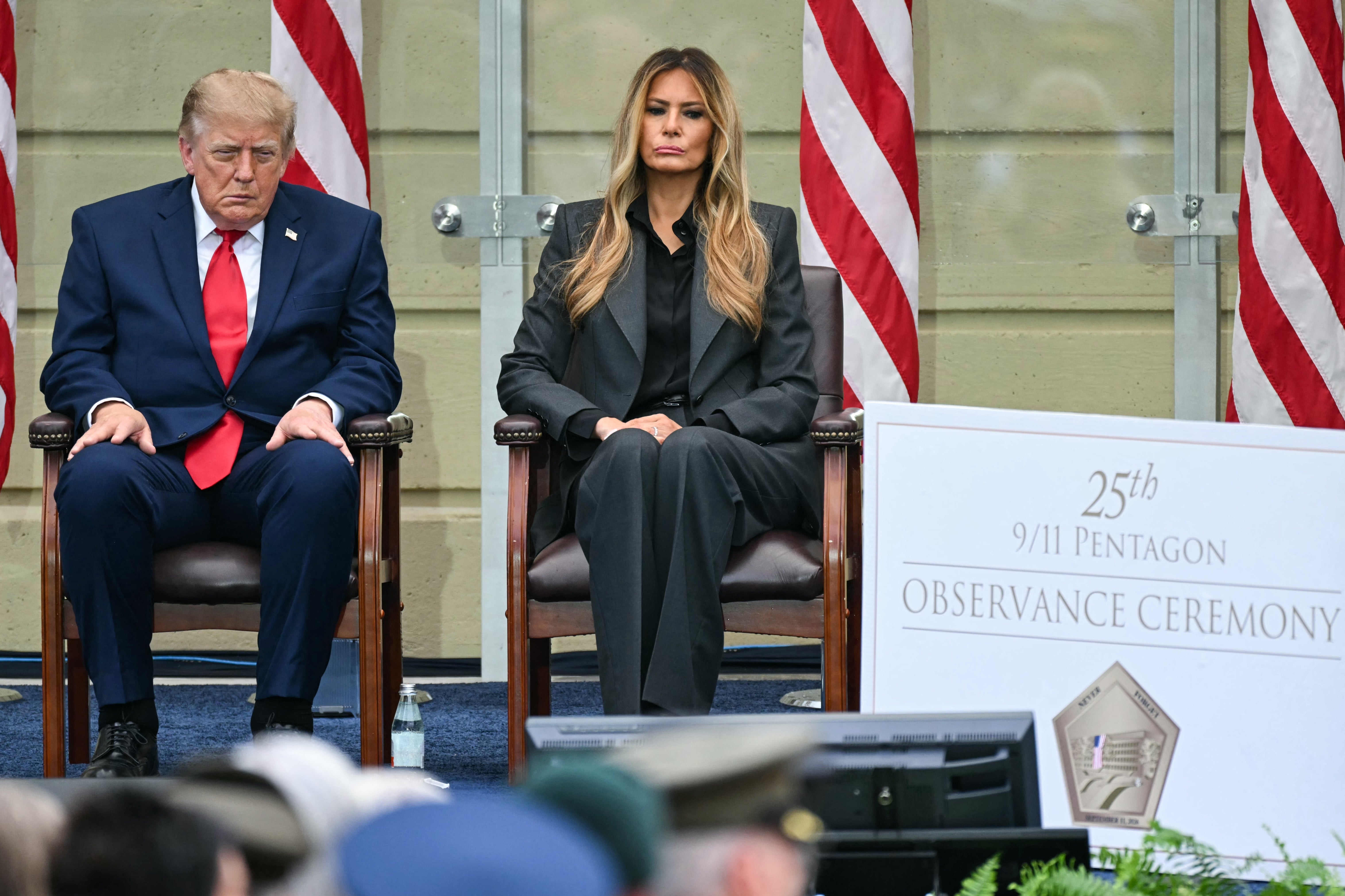 Donald og Melania Trump satt på en 9/11 Pentagon-seremoni, med flagg i bakgrunnen; han er senket fremover og ser døsig ut