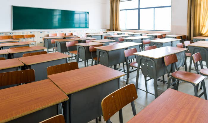 Empty schoolroom  with rows of desks, a chalkboard successful  the background