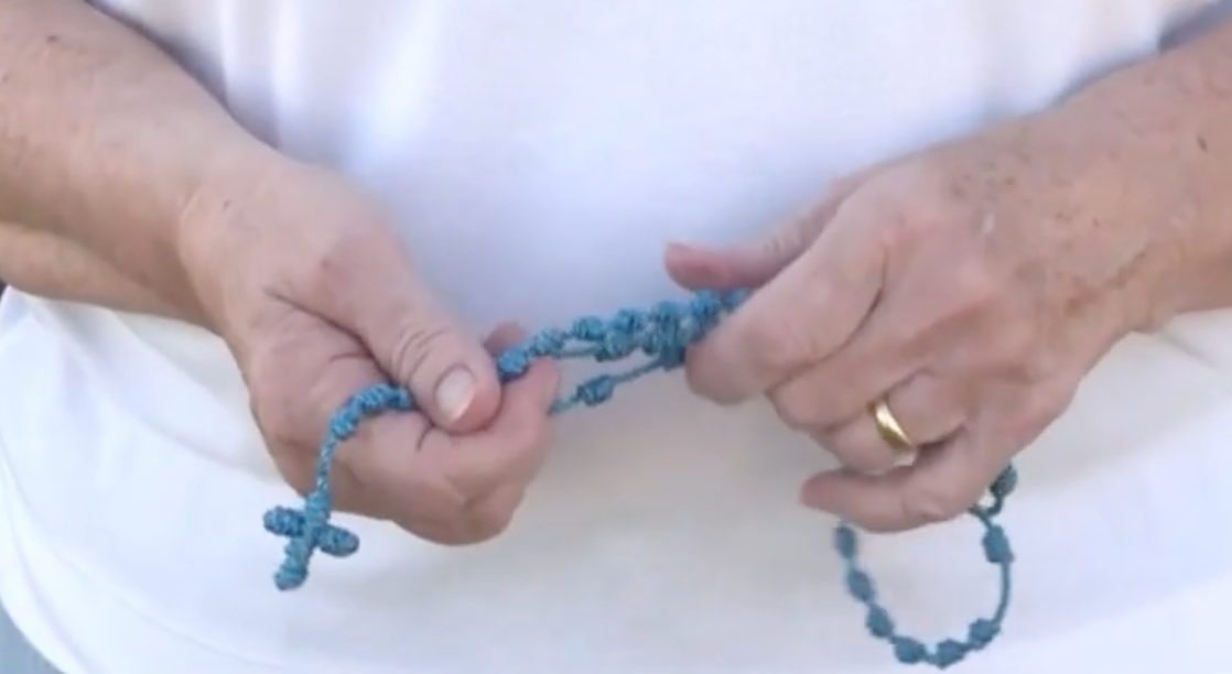 Hender som holder et sammenknyttet bønnetau, ofte brukt til meditative eller religiøse formål