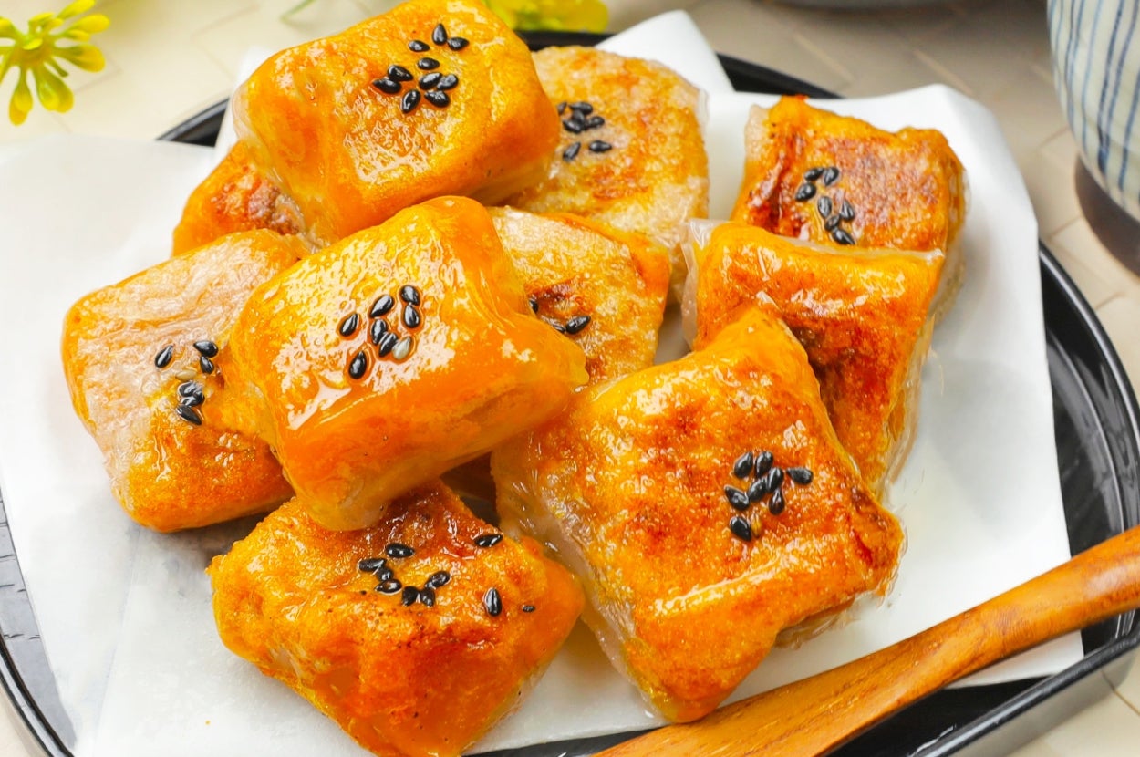 焼いたもちもちの餅が黒ごまで飾られて、皿に盛られています。