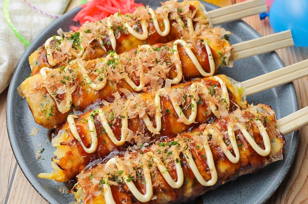 タコ焼き串がプレートに並べられている。マヨネーズとソースがかかっており、上にかつお節がのせられている。