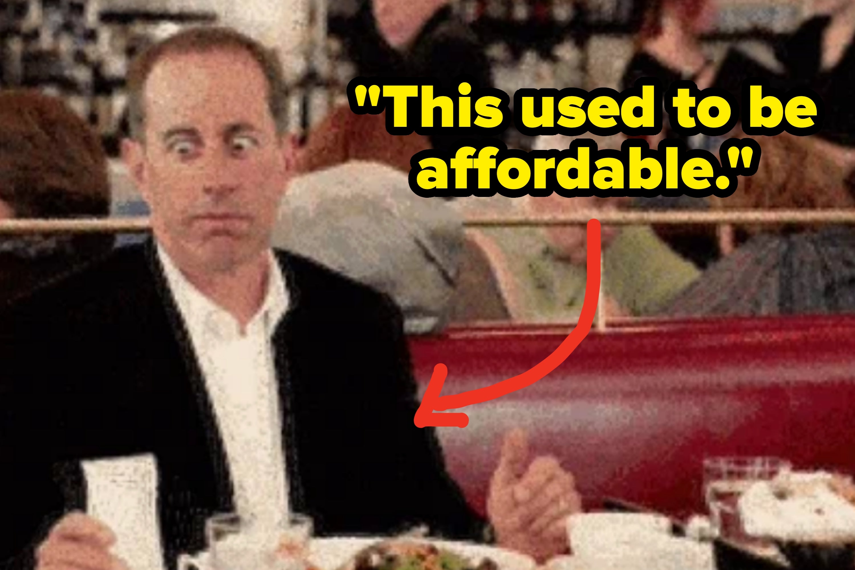 A person with a surprised expression sits in a diner, holding a receipt, with a plate of food on the table