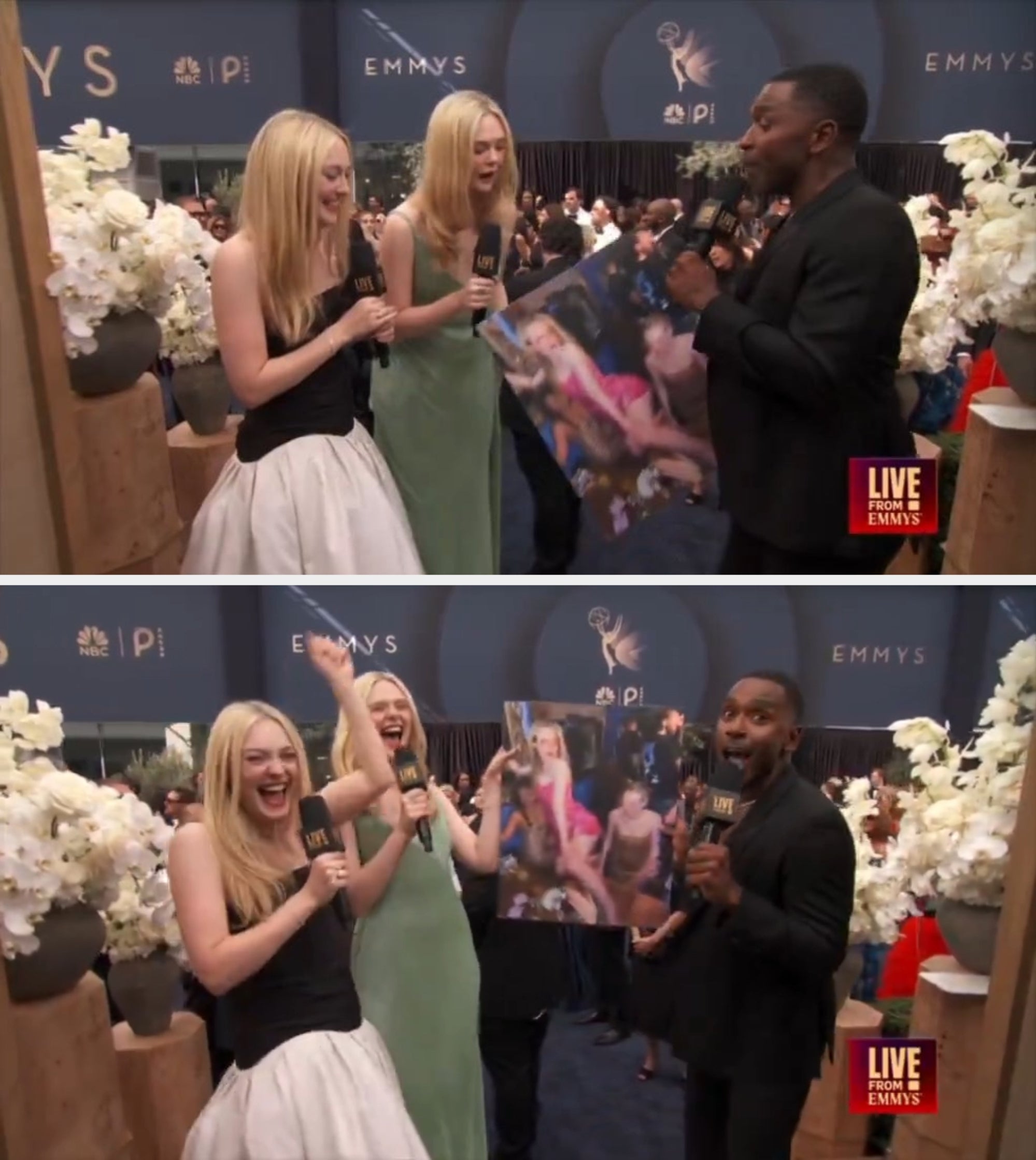 Two women in formal gowns and a man with a microphone discuss a large candid photo at a lively Emmy event