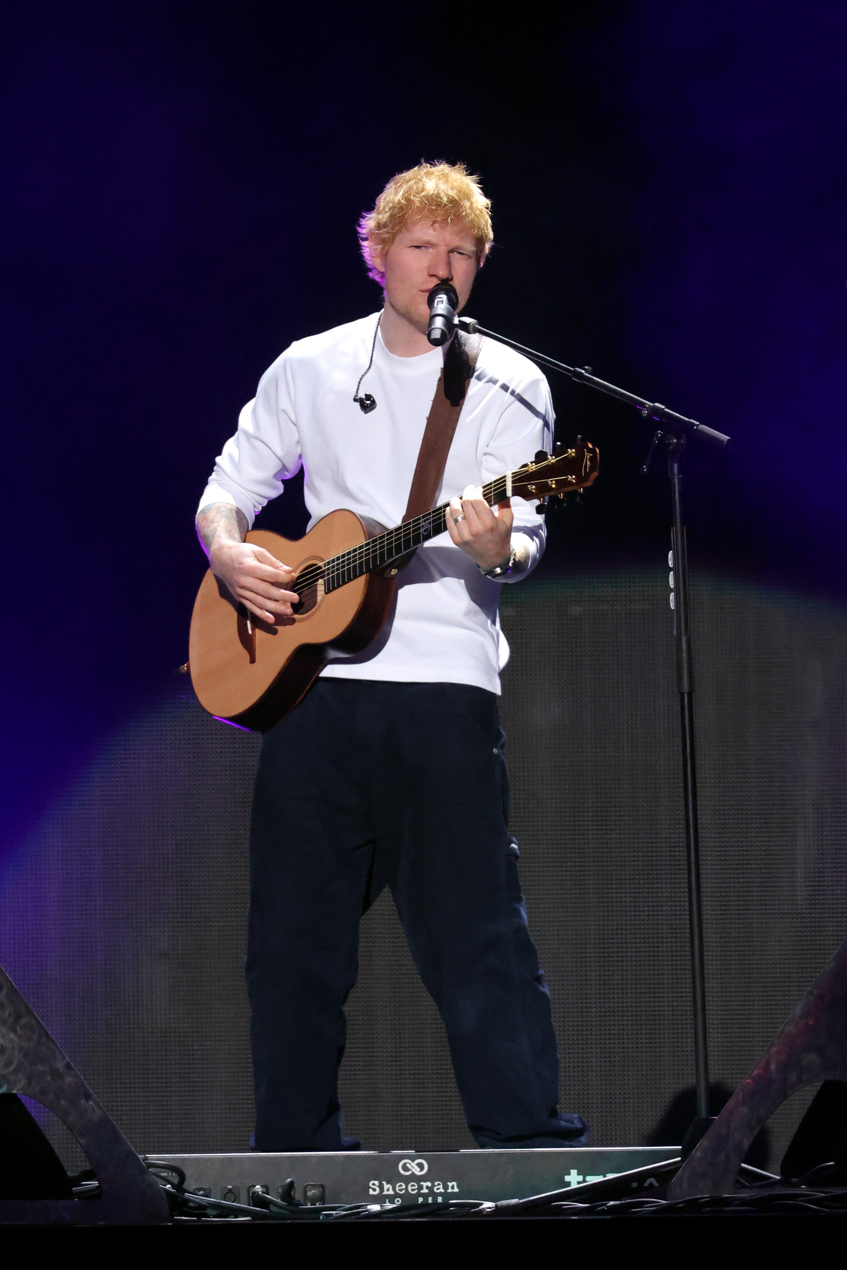 Ed opptrer på scenen med en gitar