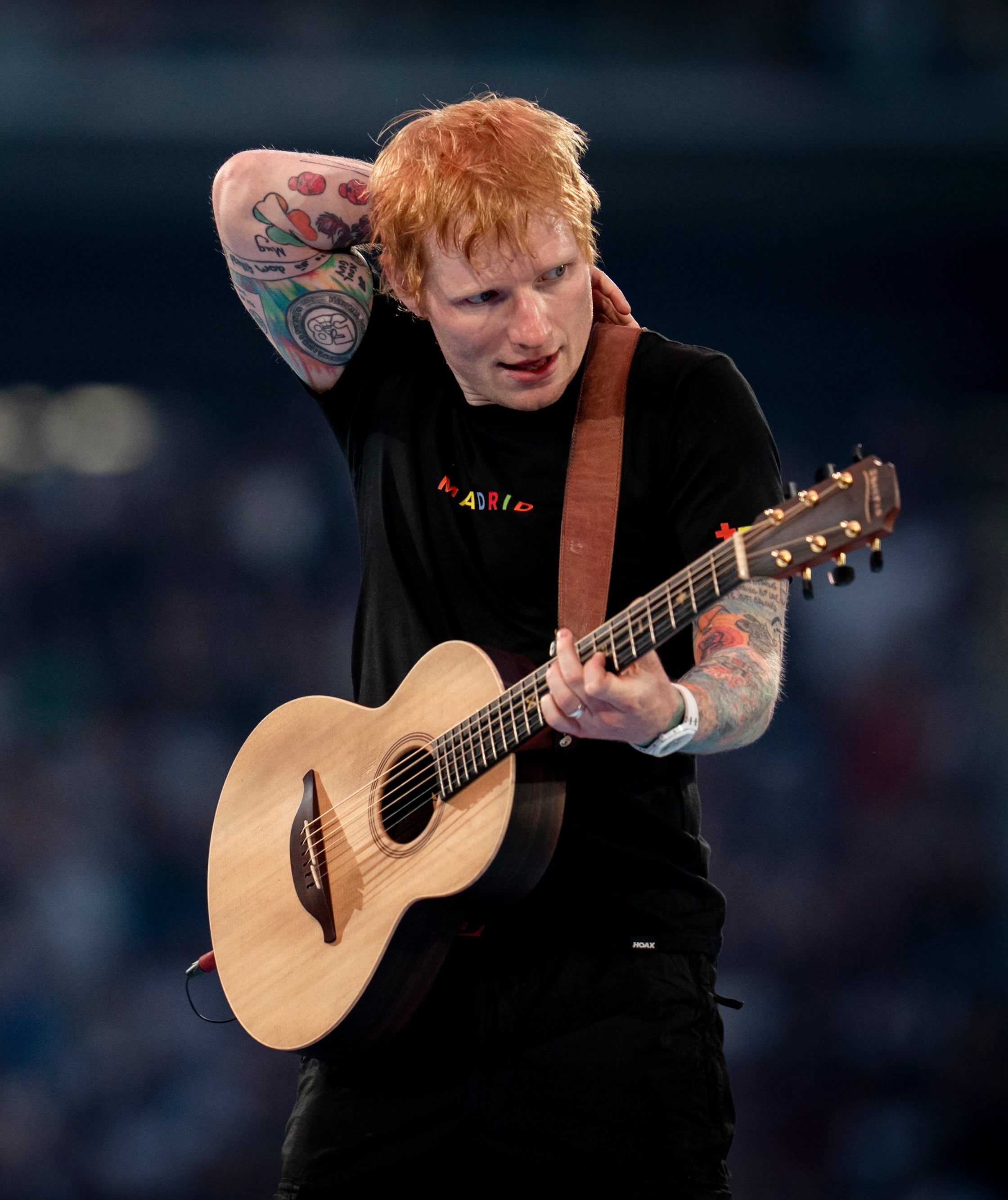 Ed på scenen, holder en akustisk gitar