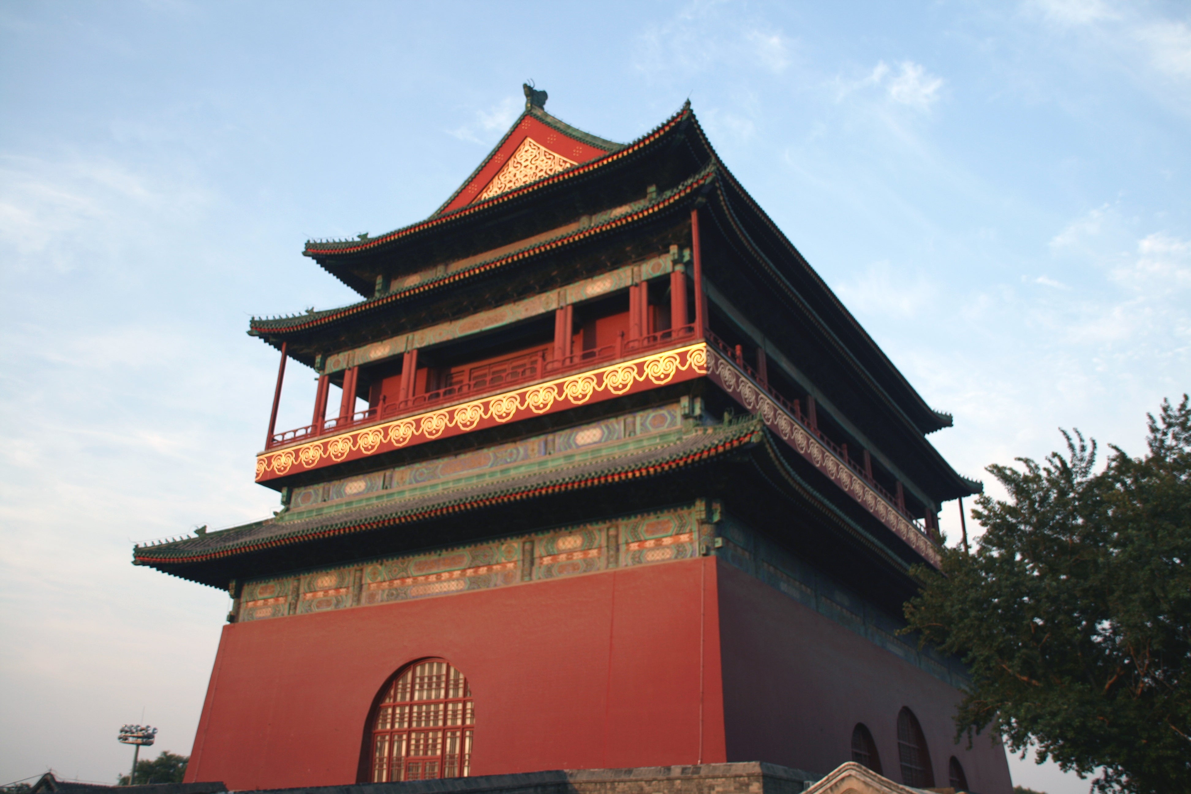 Traditional multi-tiered Chinese tower with ornate architecture, featuring decorative patterns and a trees in the foreground