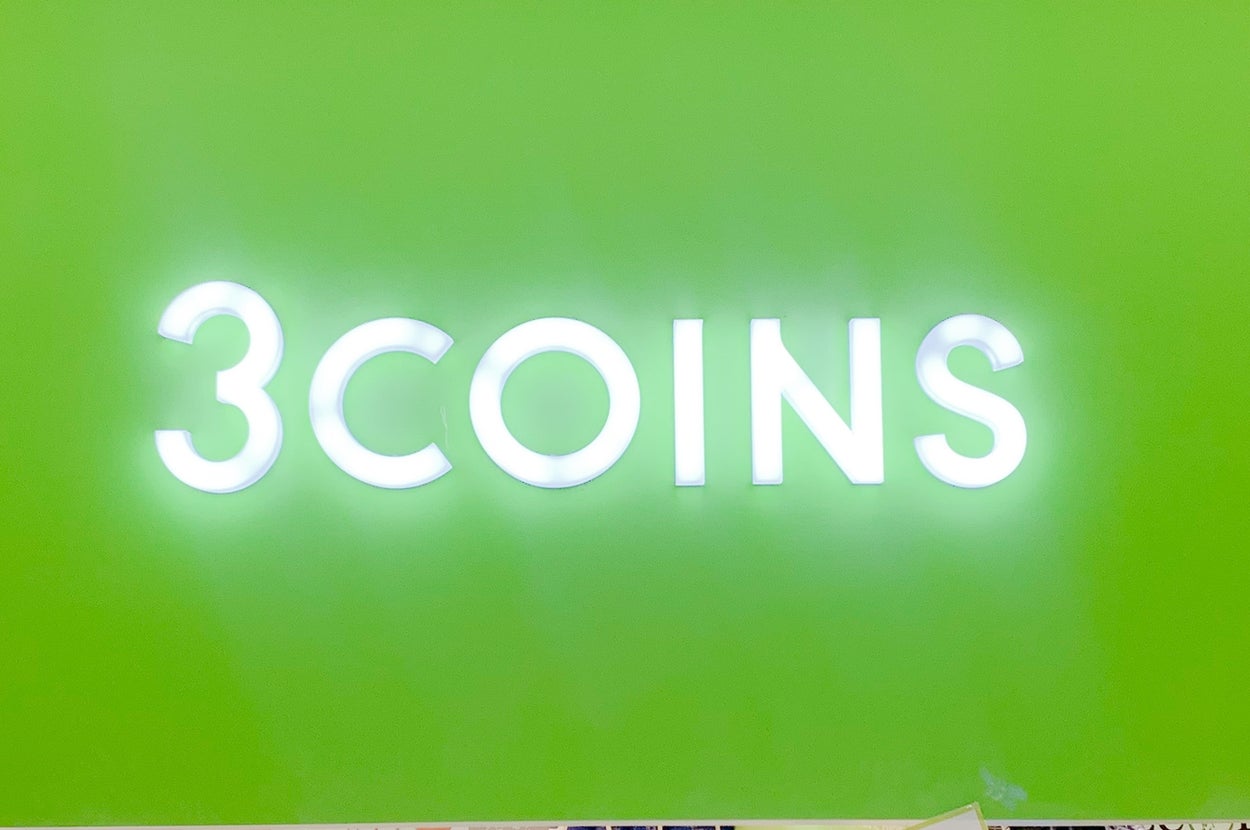 グリーンの背景に「3COINS」の光る看板。下に3%オフのプロモーションが表示されている。
