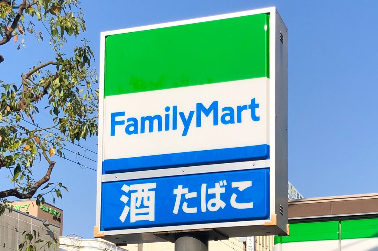 FamilyMartの看板。酒・たばこと書かれている。店舗が背景に見える。
