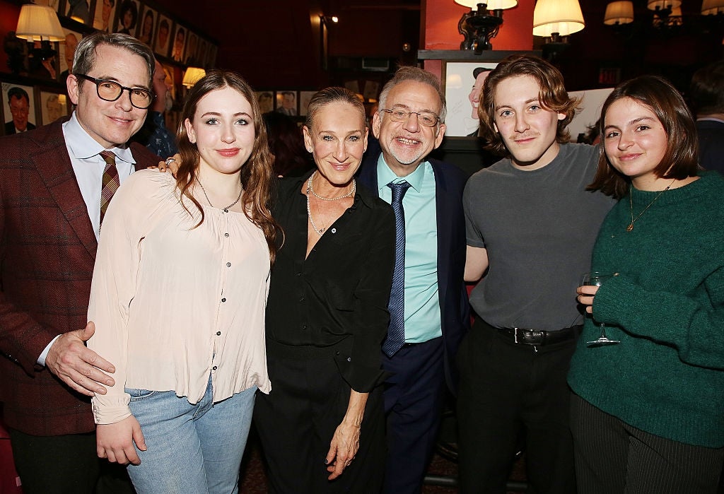 Six people are smiling and posing together in a social setting