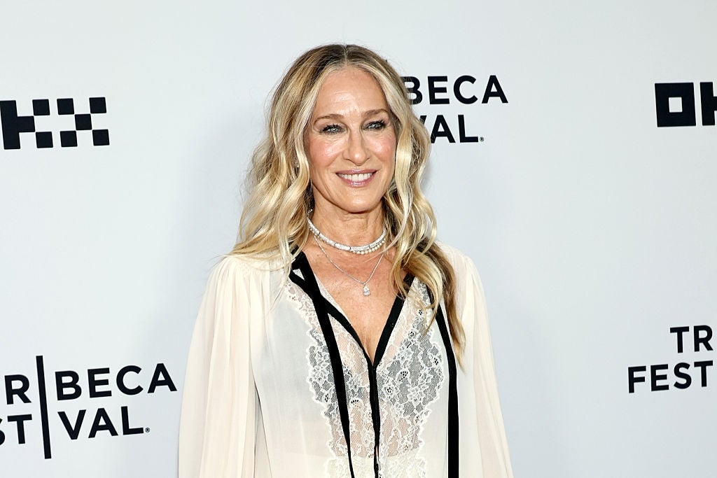 Person in a stylish lace and sheer gown at a film festival event, smiling for photos