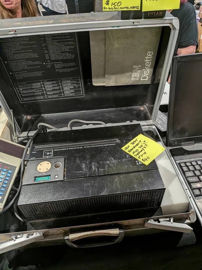 Vintage computer in a case with a floppy disk drive and label showing prices and specs