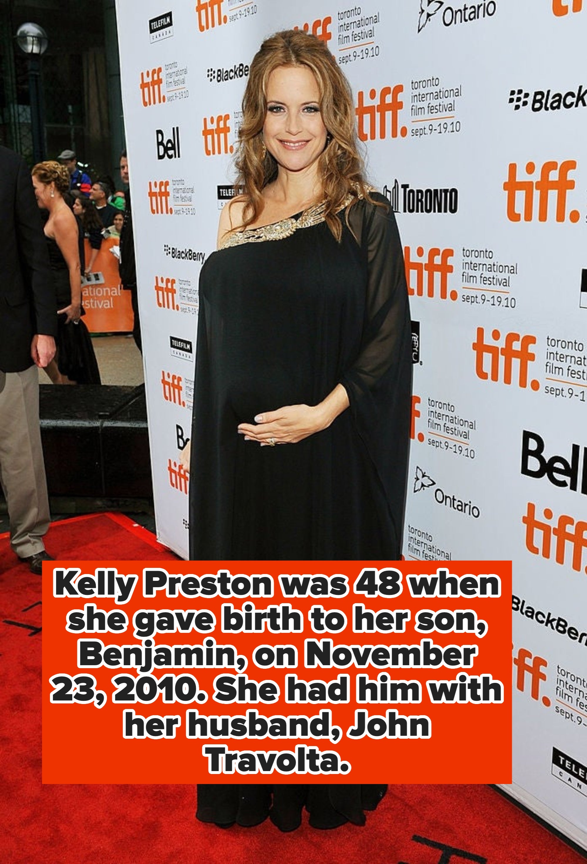 Celebrity in a flowing, one-shoulder black gown on a red carpet at a film festival event
