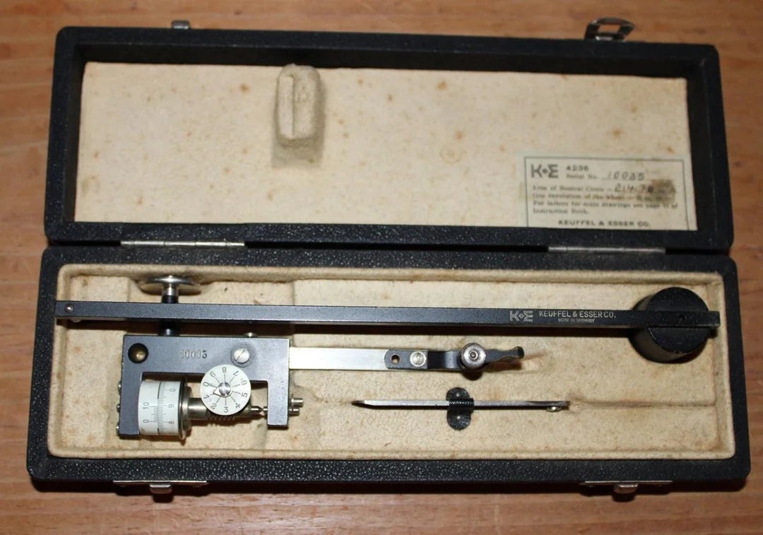 Vintage drafting compass set in an open case with precision tools neatly arranged inside