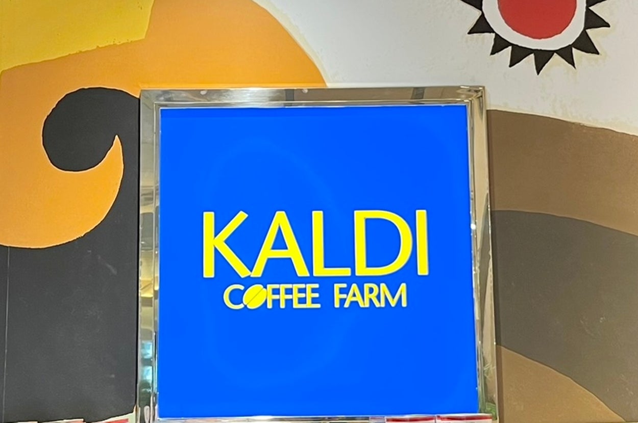 KALDI Coffee Farm店内のポップ。商品が積み上げられ、色鮮やかな壁画が背景に描かれている。