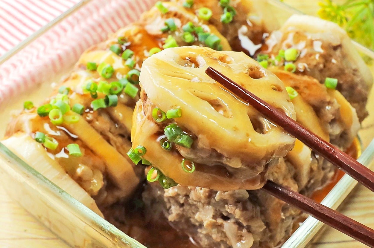 レンコンで挟んだ肉の照り焼き、青ネギを飾って盛り付け。箸で一切れ持ち上げた状態。