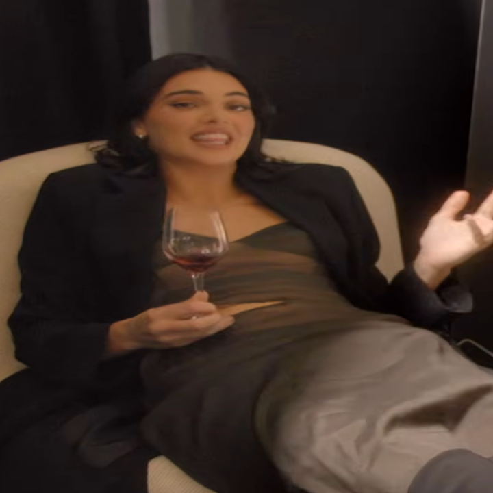 Person lounging in a chair, holding a glass of wine, wearing a sleek dress and coat. "The Kardashians" and streaming platform logos visible