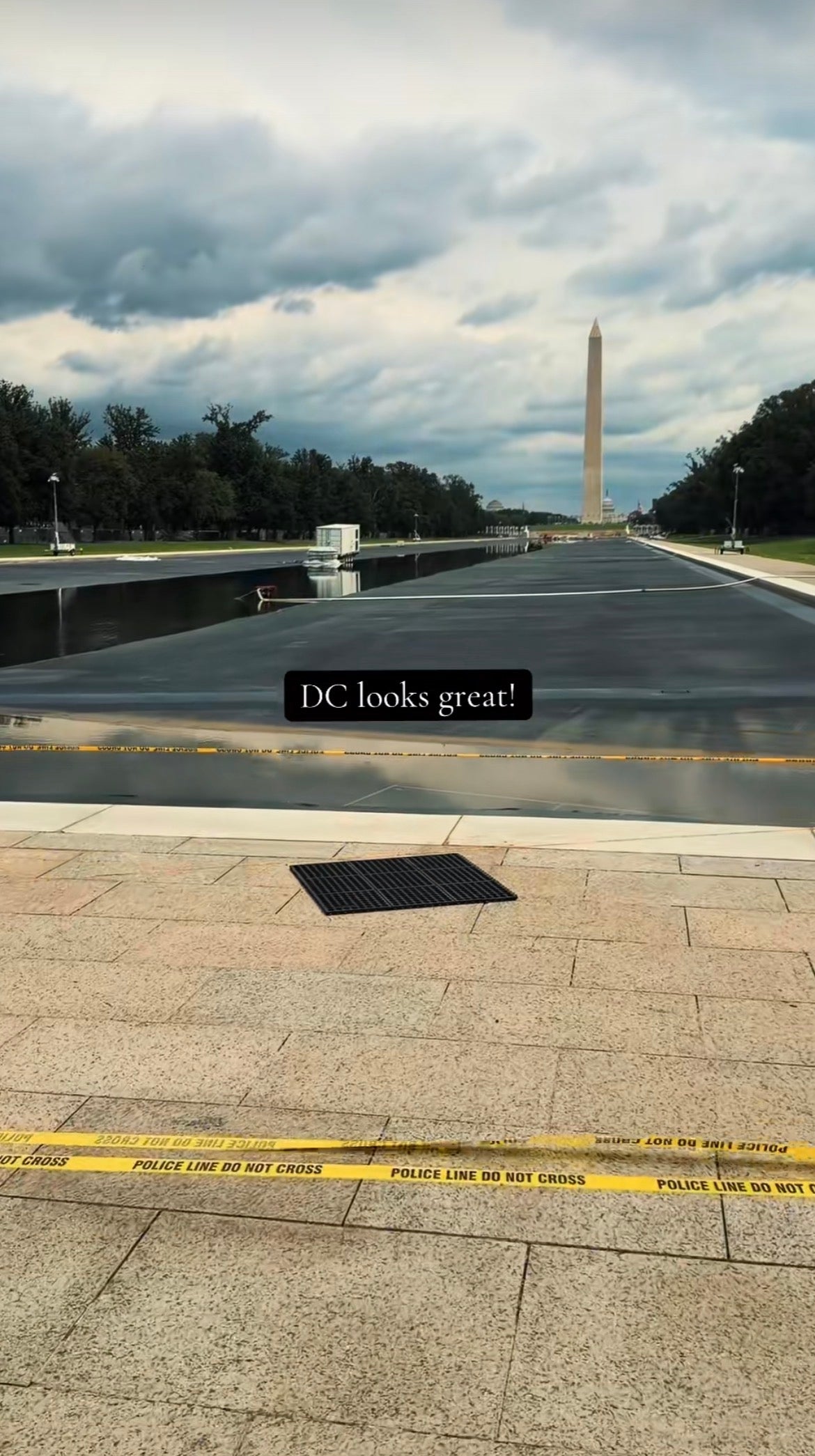 Utsikt over Washington-monumentet fra Reflecting Pool, med en politilinje og tekst som sier
