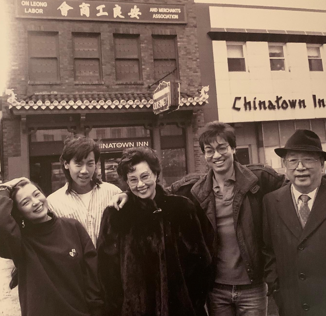 Group of 5 radical smiling successful beforehand of Chinatown Inn. They are casually dressed successful jackets and sweaters. Historic gathering successful the background