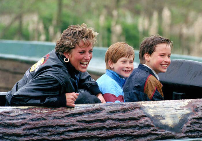 Three people smiling and enjoying a log flume ride. They are leaning forward with excitement, dressed casually with jackets appropriate for a water ride