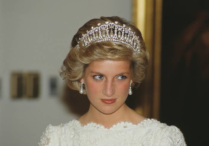 Person in elegant attire with a tiara and pearl earrings