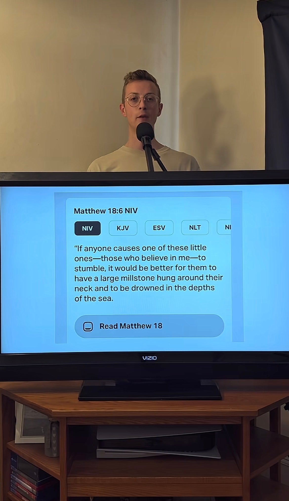 Person som står bak en skjerm som viser Matteus 18:6 fra Bibelen, og diskuterer konsekvensene for å få troende til å snuble