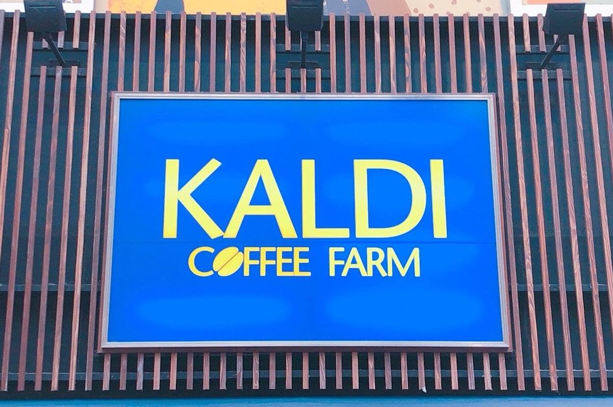 KALDI COFFEE FARMの看板。店舗を示す青い背景に黄色いロゴが中央に配置。コーヒー関連の商品を扱う店舗の目印。