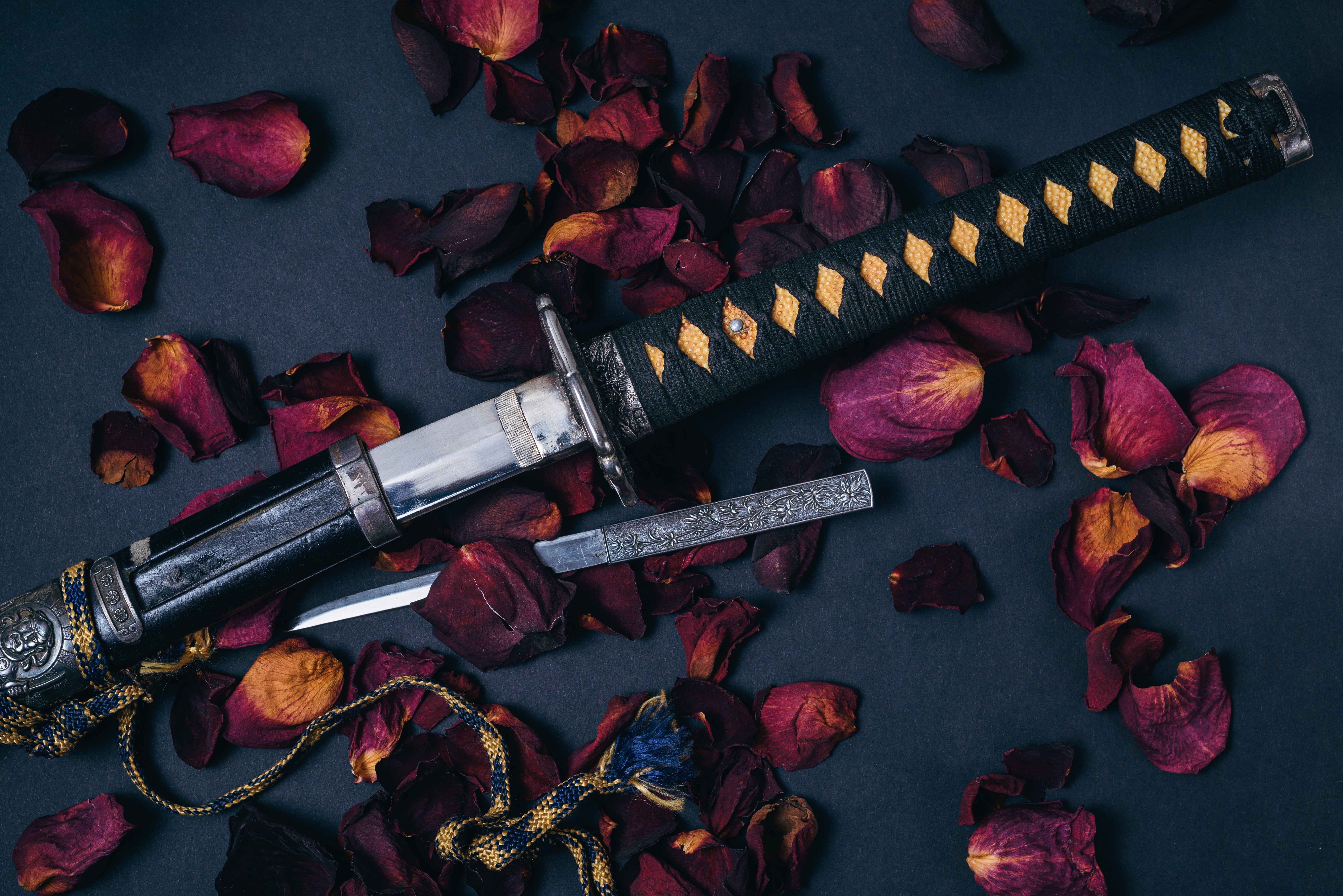 Katana-sverd blant spredte roseblader