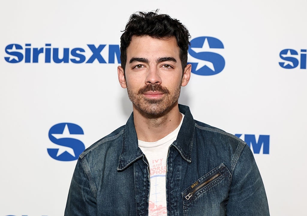 Person in casual denim jacket at SiriusXM event backdrop