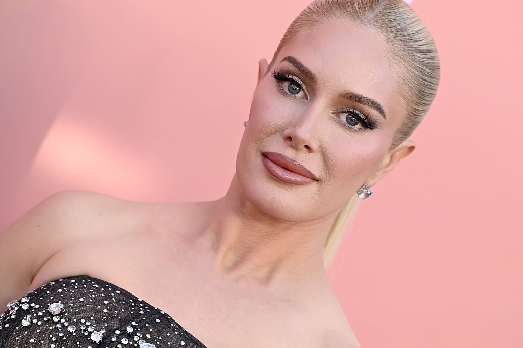 Person posing confidently, wearing a strapless, embellished gown, hair styled back